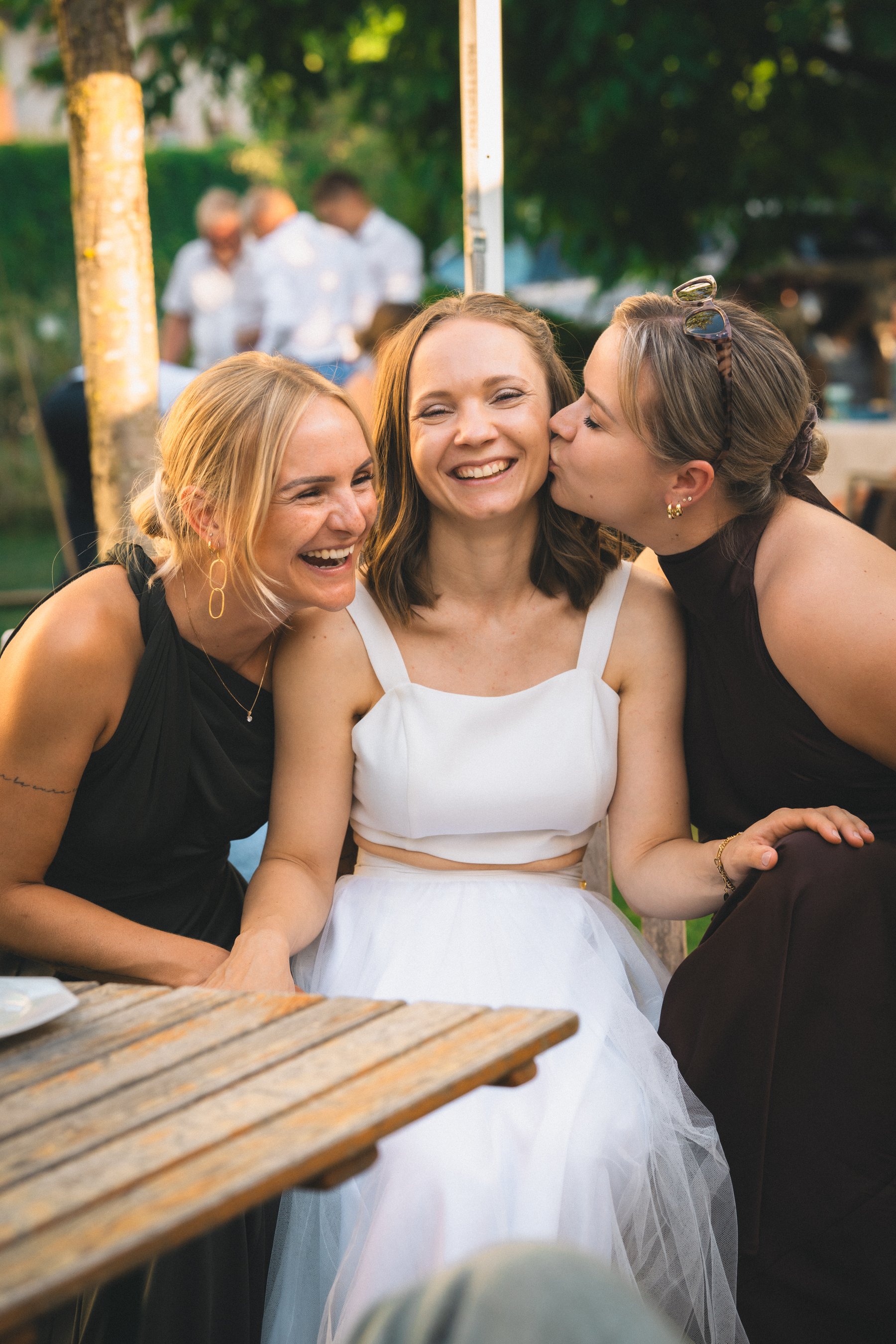Braut lacht mit ihren Freundinnen bei einer Hochzeit