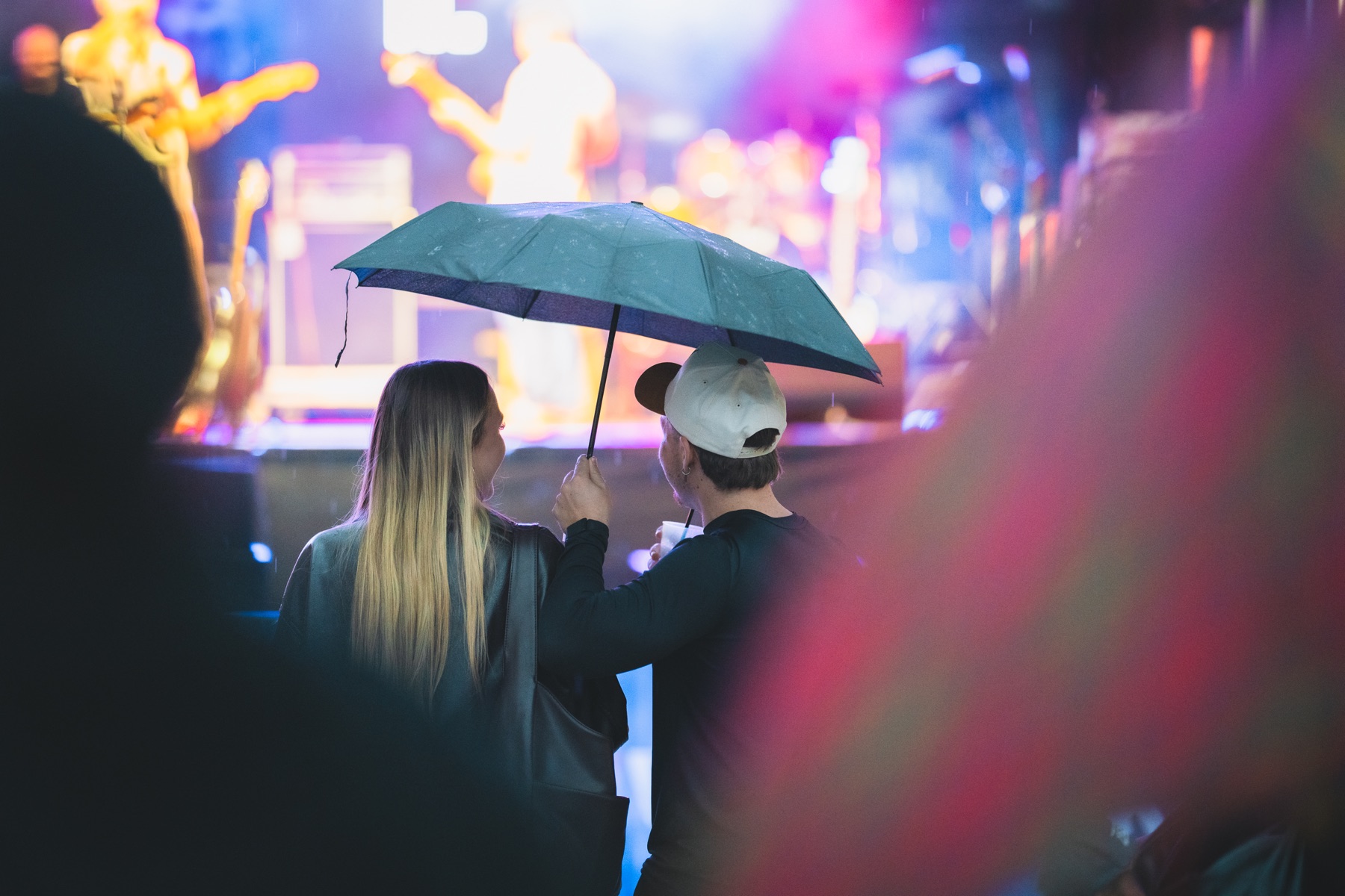 Konzertbesucher unter einem Regenschirm